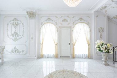 Barok tarzında lüks kraliyet iç mimarisi. Pahalı eski tarz mobilyaları olan aydınlık ve beyaz bir salon. Duvarlarda büyük pencereler ve sıva süslemeleri