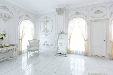 Barok tarzında lüks kraliyet iç mimarisi. Pahalı eski tarz mobilyaları olan aydınlık ve beyaz bir salon. Duvarlarda büyük pencereler ve sıva süslemeleri