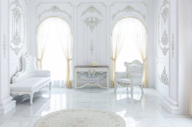 Barok tarzında lüks kraliyet iç mimarisi. Pahalı eski tarz mobilyaları olan aydınlık ve beyaz bir salon. Duvarlarda büyük pencereler ve sıva süslemeleri