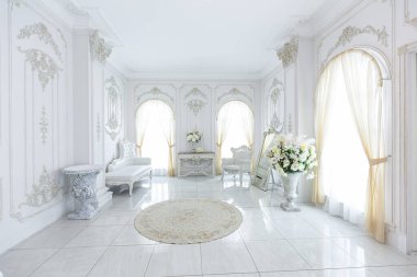 Barok tarzında lüks kraliyet iç mimarisi. Pahalı eski tarz mobilyaları olan aydınlık ve beyaz bir salon. Duvarlarda büyük pencereler ve sıva süslemeleri