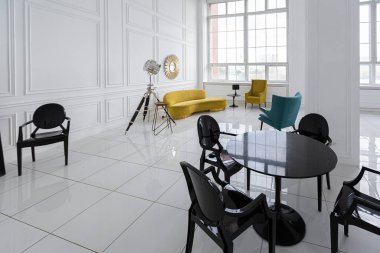 Siyah ve sarı mobilyaları olan geniş beyaz bir salonun modern modaya uygun iç tasarımı