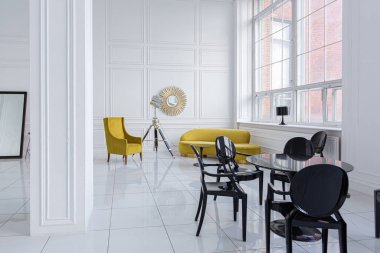 Siyah ve sarı mobilyaları olan geniş beyaz bir salonun modern modaya uygun iç tasarımı