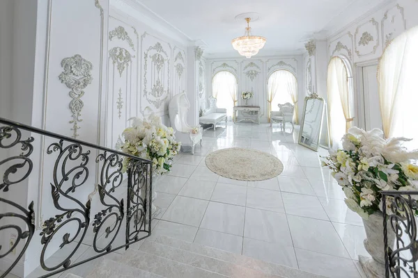 华丽的皇家豪华内饰 巴洛克风格 非常明亮 明亮和白色的大厅与昂贵的老式家具 宽阔而别致的大理石楼梯通往二楼 — 图库照片