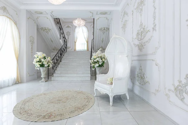 stock image luxury royal posh interior in baroque style. very bright, light and white hall with expensive oldstyle furniture. chic wide marble staircase leading to the second floor