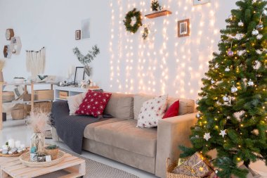 Geniş, ferah, şık, açık bir Bali tarzı dairesi asılı yatağı ve panoramik pencereleri var. Beyaz zemin ve duvarlar, basit ahşap mobilyalar. Noel ağacıyla süslenmiş.