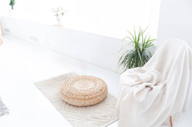 Geniş, ferah, şık, açık bir Bali tarzı dairesi asılı yatağı ve panoramik pencereleri var. Beyaz zemin ve duvarlar, basit ahşap mobilyalar..