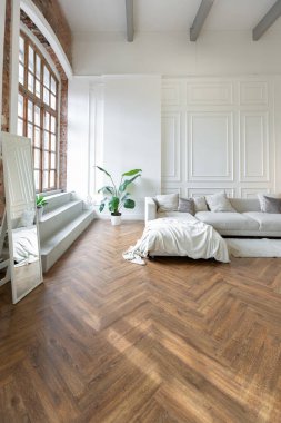 Beyaz ve gri duvarları olan, mobilyaları ve kocaman pencereleri olan, ultra modern, açık bir apartman dairesinin minimalist iç mekanı.