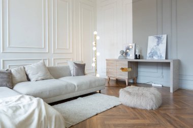 Beyaz ve gri duvarları olan, mobilyaları ve kocaman pencereleri olan, ultra modern, açık bir apartman dairesinin minimalist iç mekanı.