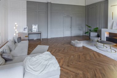 Beyaz ve gri duvarları olan, mobilyaları ve kocaman pencereleri olan, ultra modern, açık bir apartman dairesinin minimalist iç mekanı.