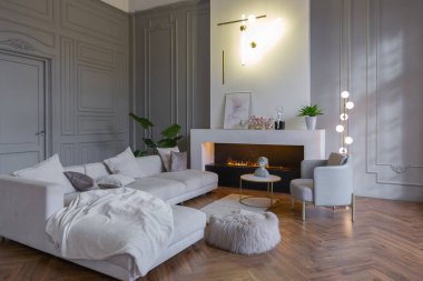 Beyaz ve gri duvarları olan, mobilyaları ve kocaman pencereleri olan, ultra modern, açık bir apartman dairesinin minimalist iç mekanı.