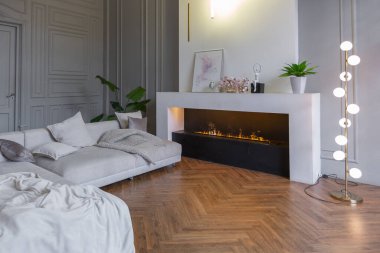 Beyaz ve gri duvarları olan, mobilyaları ve kocaman pencereleri olan, ultra modern, açık bir apartman dairesinin minimalist iç mekanı.