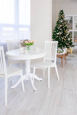 Lüks, pahalı, açık renkli bir daire. Modern, minimalist tasarım. Güneş ışığıyla dolu. Noel ağacıyla süslenmiş bir sürü yer.