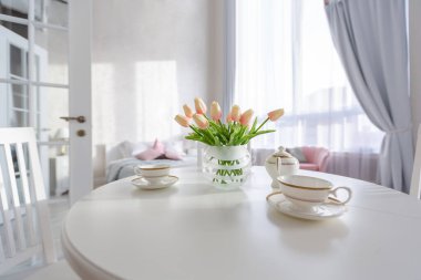 Açık renkli, lüks ve pahalı bir apartman dairesi. Minimum tasarım, yemek alanı ve misafir odası olan modern yatak odası..