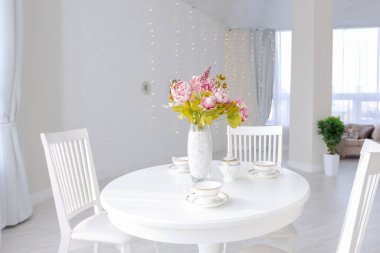 Açık renkli, lüks ve pahalı bir apartman dairesi. Minimum tasarım, yemek alanı ve misafir odası olan modern yatak odası..