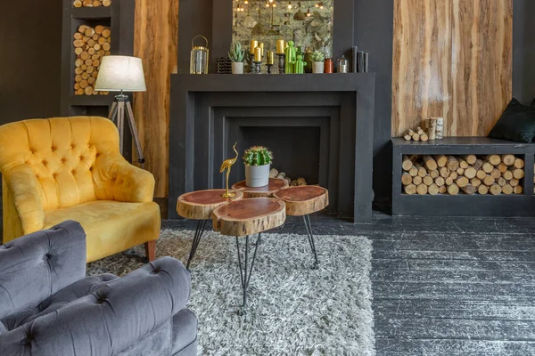 stock image dark brutal interior of sitting room decorated with wooden logs. yellow and grey soft armchairs, huge arc window and fireplace