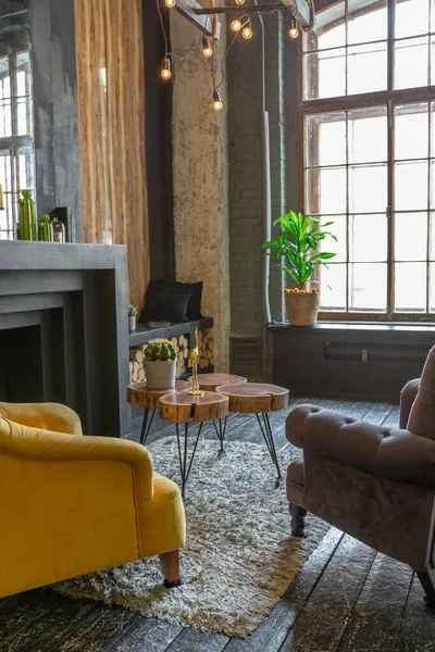 用木制圆木装饰的客厅的黑暗而野蛮的内部 黄色和灰色软扶手椅 巨大的弧形窗户和壁炉 — 图库照片