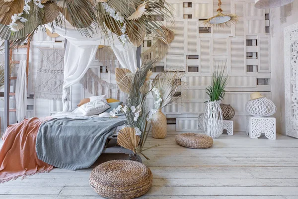 stock image Balinese style bedroom interior. canopy bed with lots of textiles for decoration and wicker items in soft pastel colors