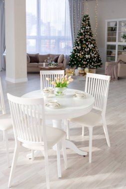 Lüks, pahalı, açık renkli bir daire. Modern, minimalist tasarım. Güneş ışığıyla dolu. Noel ağacıyla süslenmiş bir sürü yer.
