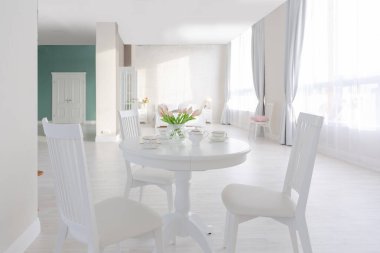 Açık renkli, lüks ve pahalı bir apartman dairesi. Minimum tasarım, yemek alanı ve misafir odası olan modern yatak odası..