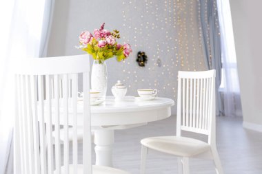Açık renkli, lüks ve pahalı bir apartman dairesi. Minimum tasarım, yemek alanı ve misafir odası olan modern yatak odası..