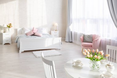 Lüks, zengin, açık renkli, pahalı bir apartman dairesinde minimalist bir tasarımı olan modern yatak odası..