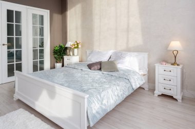 Lüks, zengin, açık renkli, pahalı bir apartman dairesinde minimalist bir tasarımı olan modern yatak odası..