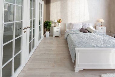Lüks, zengin, açık renkli, pahalı bir apartman dairesinde minimalist bir tasarımı olan modern yatak odası..