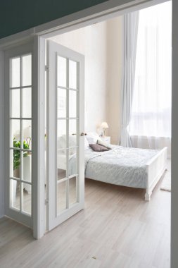 Lüks, zengin, açık renkli, pahalı bir apartman dairesinde minimalist bir tasarımı olan modern yatak odası..