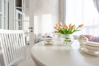 Açık renkli, lüks ve pahalı bir apartman dairesi. Minimum tasarım, yemek alanı ve misafir odası olan modern yatak odası..