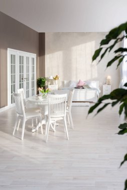 Açık renkli, lüks ve pahalı bir apartman dairesi. Minimum tasarım, yemek alanı ve misafir odası olan modern yatak odası..