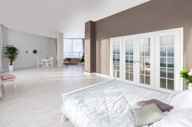Açık renkli, lüks ve pahalı bir apartman dairesi. Minimum tasarım, yemek alanı ve misafir odası olan modern yatak odası..