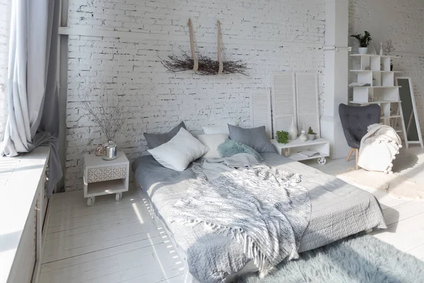 宽敞时尚的现代时尚阁楼公寓 白色和浅色 一个充满阳光的大房间 木地板 托盘床和巨大的窗户 所有的东西都是白色的 带有灰色的色调 — 图库照片