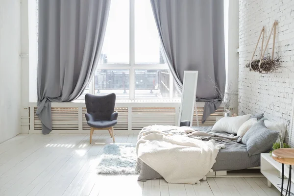 宽敞时尚的现代时尚阁楼公寓 白色和浅色 一个充满阳光的大房间 木地板 托盘床和巨大的窗户 所有的东西都是白色的 带有灰色的色调 — 图库照片
