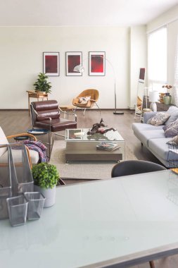 Mavi ve bej renkli, büyük pencereli ve gün ışığında minimalizm tarzında oturma alanı olan kişisel stüdyo ofisinin modern modaya uygun yaratıcı tasarımı