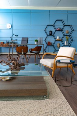 Mavi ve bej renkli, büyük pencereli ve gün ışığında minimalizm tarzında oturma alanı olan kişisel stüdyo ofisinin modern modaya uygun yaratıcı tasarımı