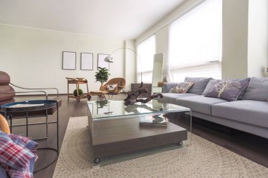 Mavi ve bej renkli, büyük pencereli ve gün ışığında minimalizm tarzında oturma alanı olan kişisel stüdyo ofisinin modern modaya uygun yaratıcı tasarımı