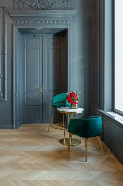 19. yüzyılın Rönesans tarzında modern lüks mobilyaları olan şık bir oda. Asil koyu renkli duvarlar alçı ve yaldızlı çerçevelerle süslenmiş, ahşap parke..