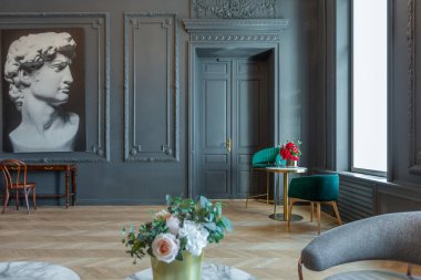 19. yüzyılın Rönesans tarzında modern lüks mobilyaları olan şık bir oda. Asil koyu renkli duvarlar alçı ve yaldızlı çerçevelerle süslenmiş, ahşap parke..