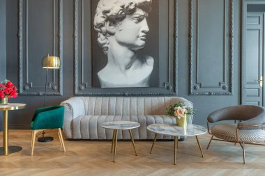 chic interior of the room in the Renaissance style of the 19th century with modern luxury furniture. walls of noble dark color are decorated with stucco and gilded frames, wooden parquet. clipart