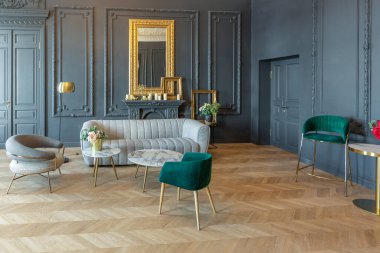 19. yüzyılın Rönesans tarzında modern lüks mobilyaları olan şık bir oda. Asil koyu renkli duvarlar alçı ve yaldızlı çerçevelerle süslenmiş, ahşap parke..