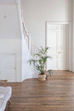 İki katlı, balkon tarzı dekoratif eşyalarla dolu, parlak bir dairede modern bir oda. Beyaz duvarlar, ahşap döşemeler ve eski mobilyalar.