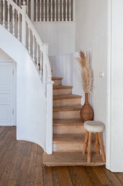 İki katlı, balkon tarzı dekoratif eşyalarla dolu, parlak bir dairede modern bir oda. Beyaz duvarlar, ahşap döşemeler ve eski mobilyalar.