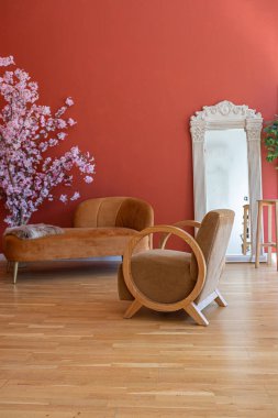 19. yüzyıl tarzı oturma odası. Parlak kırmızı duvarları, ahşap zemini ve odanın içinde doğrudan güneş ışığı var..