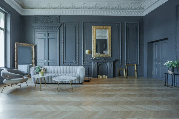chic interior of the room in the Renaissance style of the 19th century with modern luxury furniture. walls of noble dark color are decorated with stucco and gilded frames, wooden parquet.