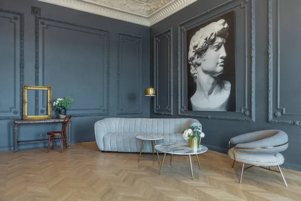 stock image chic interior of the room in the Renaissance style of the 19th century with modern luxury furniture. walls of noble dark color are decorated with stucco and gilded frames, wooden parquet.