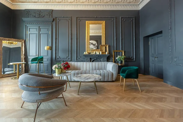 stock image chic interior of the room in the Renaissance style of the 19th century with modern luxury furniture. walls of noble dark color are decorated with stucco and gilded frames, wooden parquet.