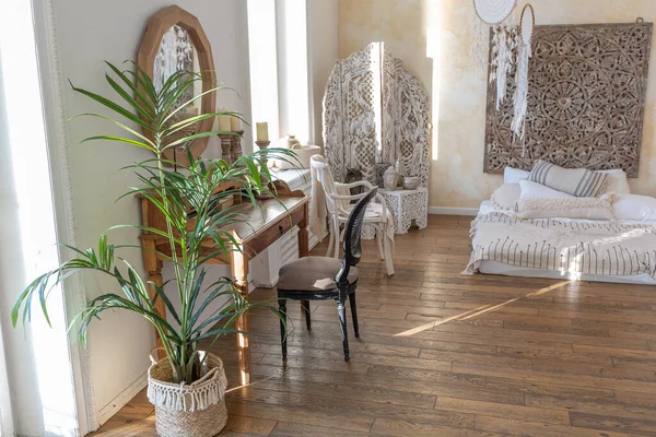 İki katlı, balkon tarzı dekoratif eşyalarla dolu, parlak bir dairede modern bir oda. Beyaz duvarlar, ahşap döşemeler ve eski mobilyalar.