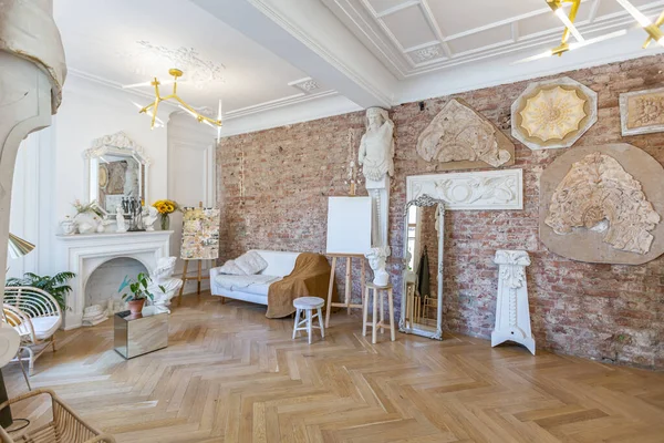 stock image bright workshop room for the creation and work of an architect and artist in a loft style with brick walls and parquet. the walls are decorated with examples of stucco.