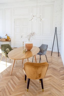 Ahşap elementleri ve beyaz duvarları olan geniş bir oturma odasının pahalı, hafif, lüks iç tasarımı. Orijinal ve alışılmadık dekoratif şeylerle dolu.