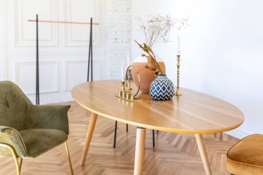 Ahşap elementleri ve beyaz duvarları olan geniş bir oturma odasının pahalı, hafif, lüks iç tasarımı. Orijinal ve alışılmadık dekoratif şeylerle dolu.